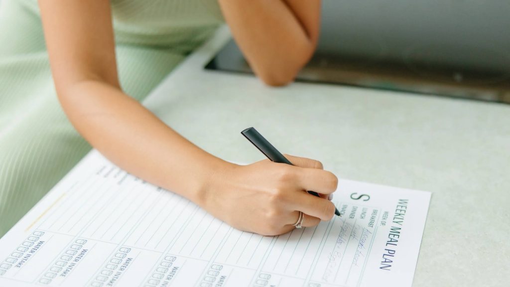 a woman making a weekly meal plan