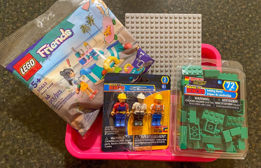 party favors small tray, small base board, green building blocks, three small people figurines, LEGO Friends set