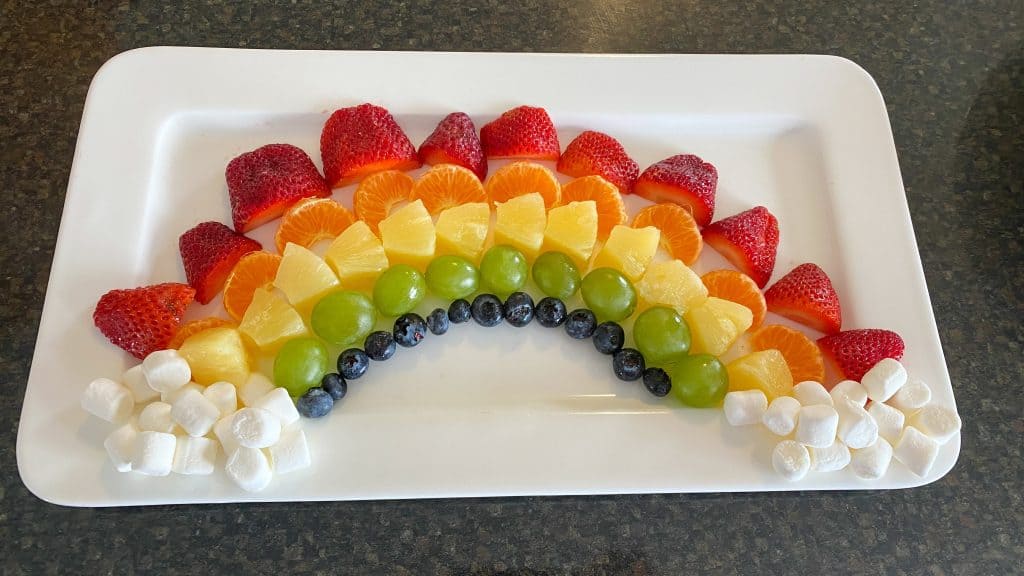 rainbow made out of fruit and mini marshmallows as clouds