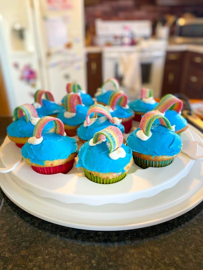 cupcakes with blue frosting, candy as a rainbow, white frosting clouds