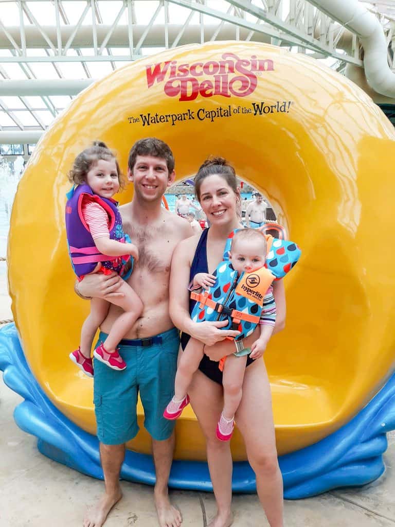 family in swimsuits standing in front of Wisconsin Dells sign