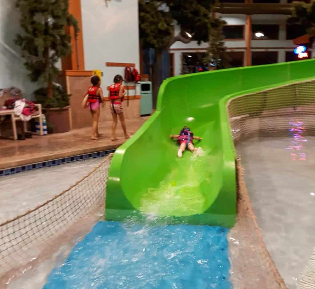 toddler on stomach going down indoor water slide