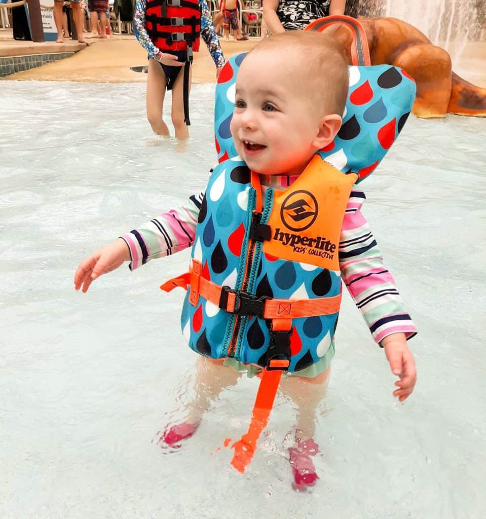 toddler in pool wearing life jacket