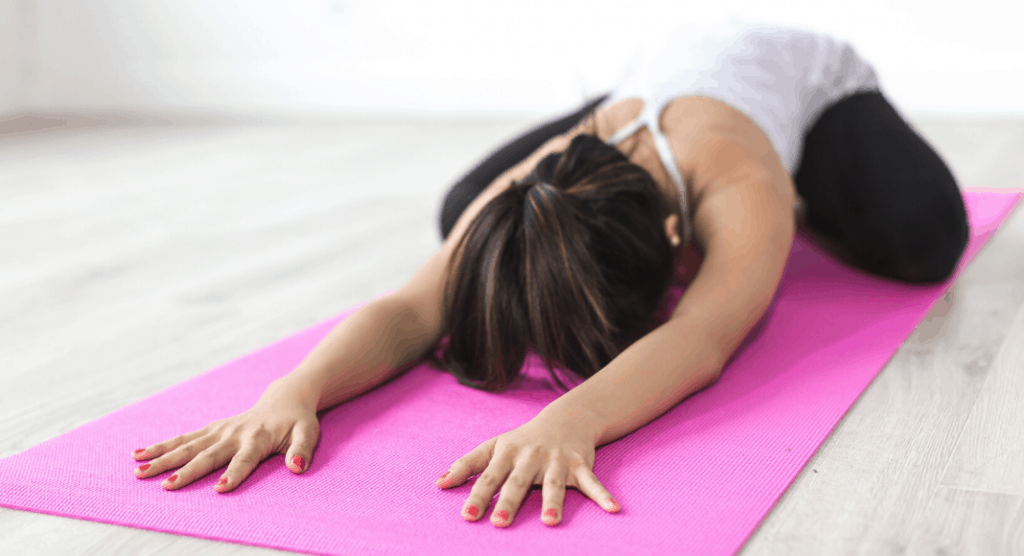 woman practicing yoga on mat