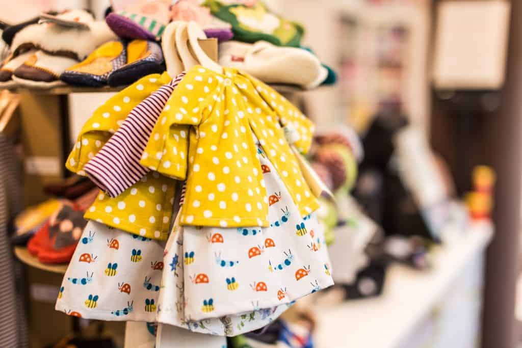 baby dress and sweater on a hanger